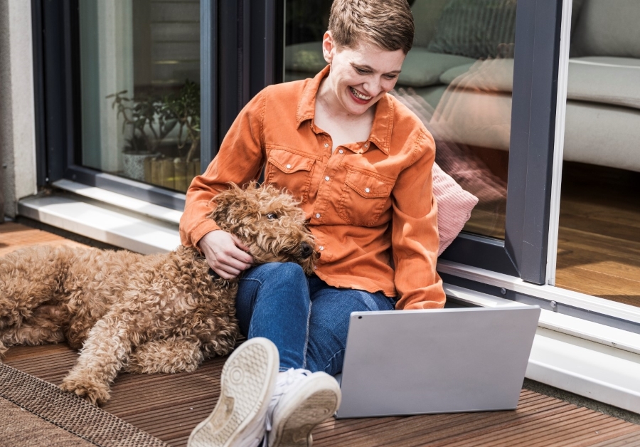 Kobieta z laptopem i psem na kolanach