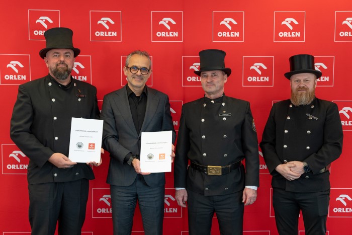 Artur Stawiarski, Prezes Zarządu myORLEN sp. z o.o. oraz trzej kominiarze w tradycyjnych strojach (czarne mundury i kapelusze). Stoją na tle ścianki z logiem ORLEN. Trzymają w rękach podpisane Poruzumienie.